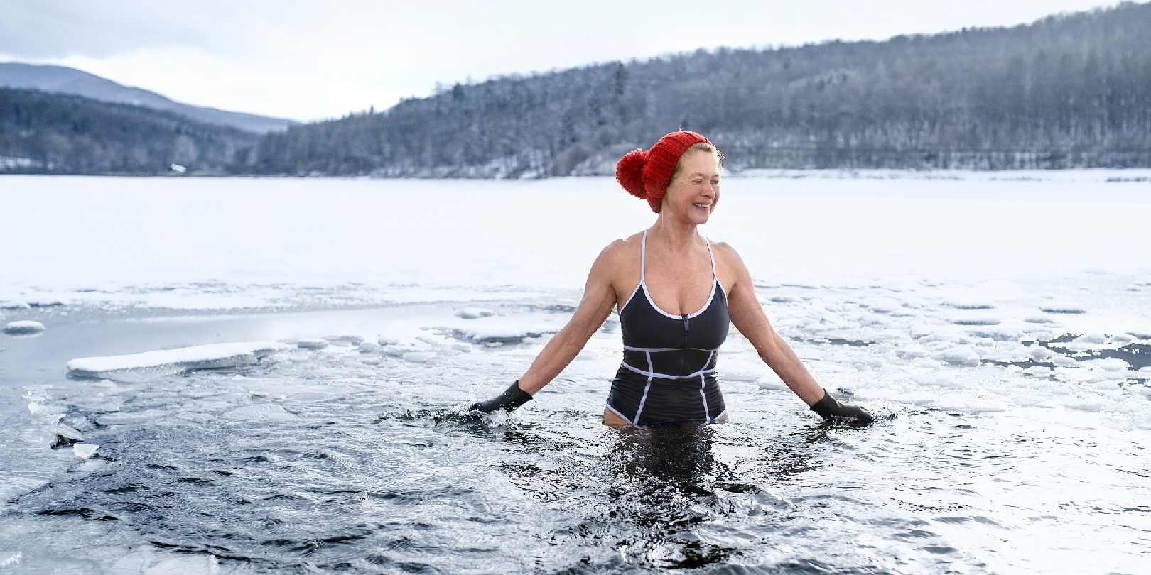 benefits-of-swimming the-independence Front view of active senior woman in swimsuit outdoors in water in winter, cold therapy concept