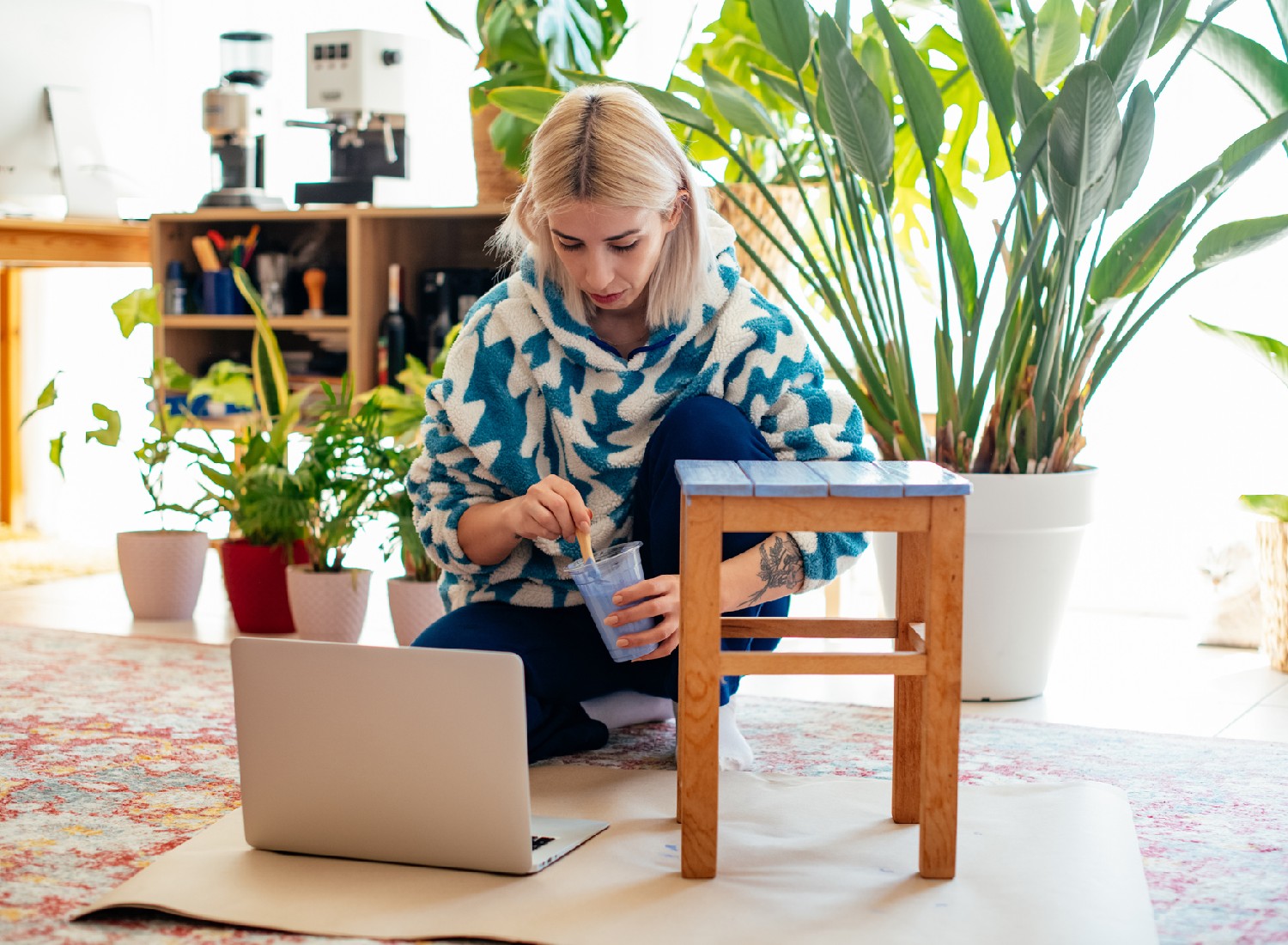 Young Woman is Painting Coffee Table With Online Workshop