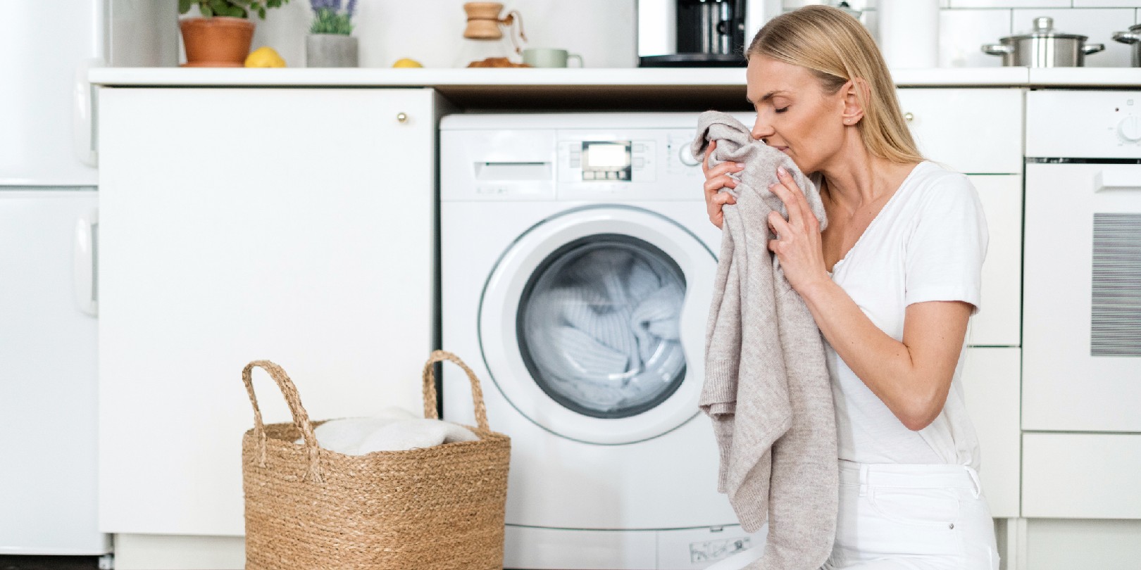 Young woman smell clean wool sweater after washing at home