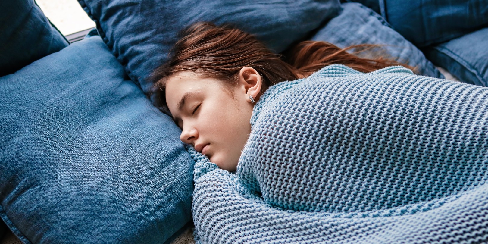 fall-asleep-faster the-independence Young teenager girl sleeping snuggled in warm knitted blue blanket