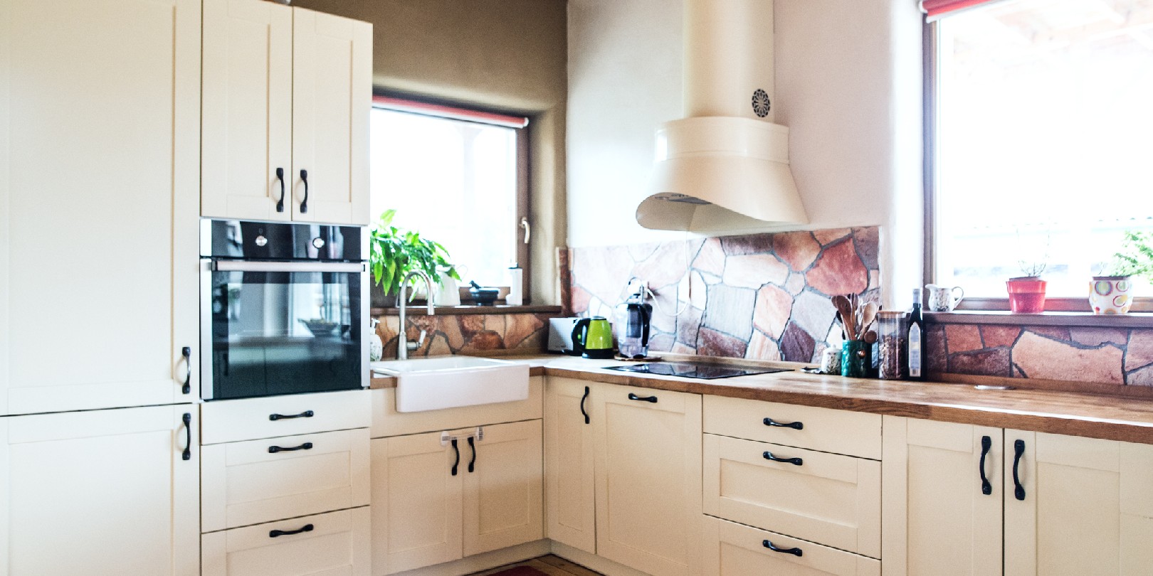 trendy-wall-colour the-independence An oven, sink, cooker and cabinets in the kitchen.