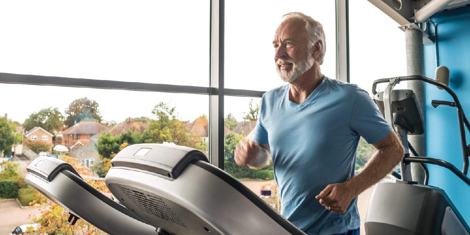 best-gyms-in-london the-independence Man in his 60s running in the gym by a window, he is focused and healthy, with white hair and beard