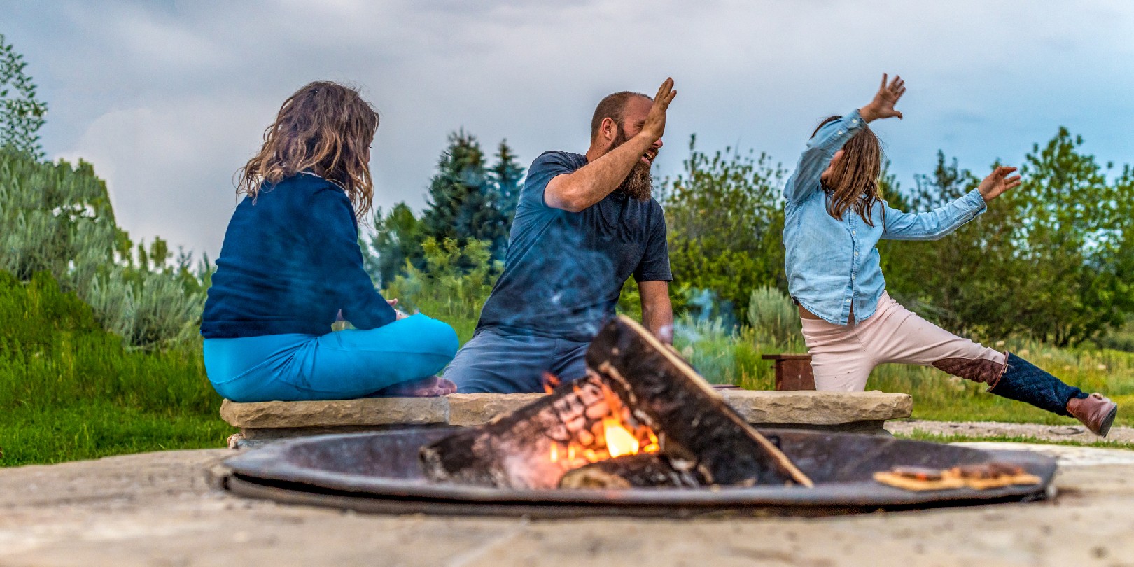 campfire-games the-independence Father on a camping trip with his daughters playing cards around a campfire