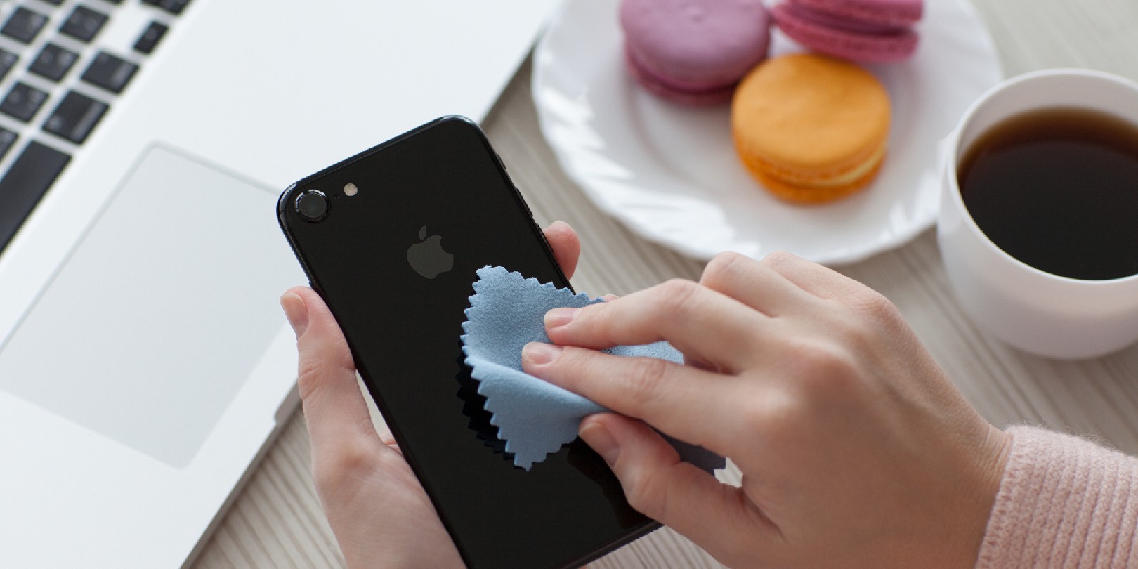 Woman hand holding iPhone 7 and cleaning it.