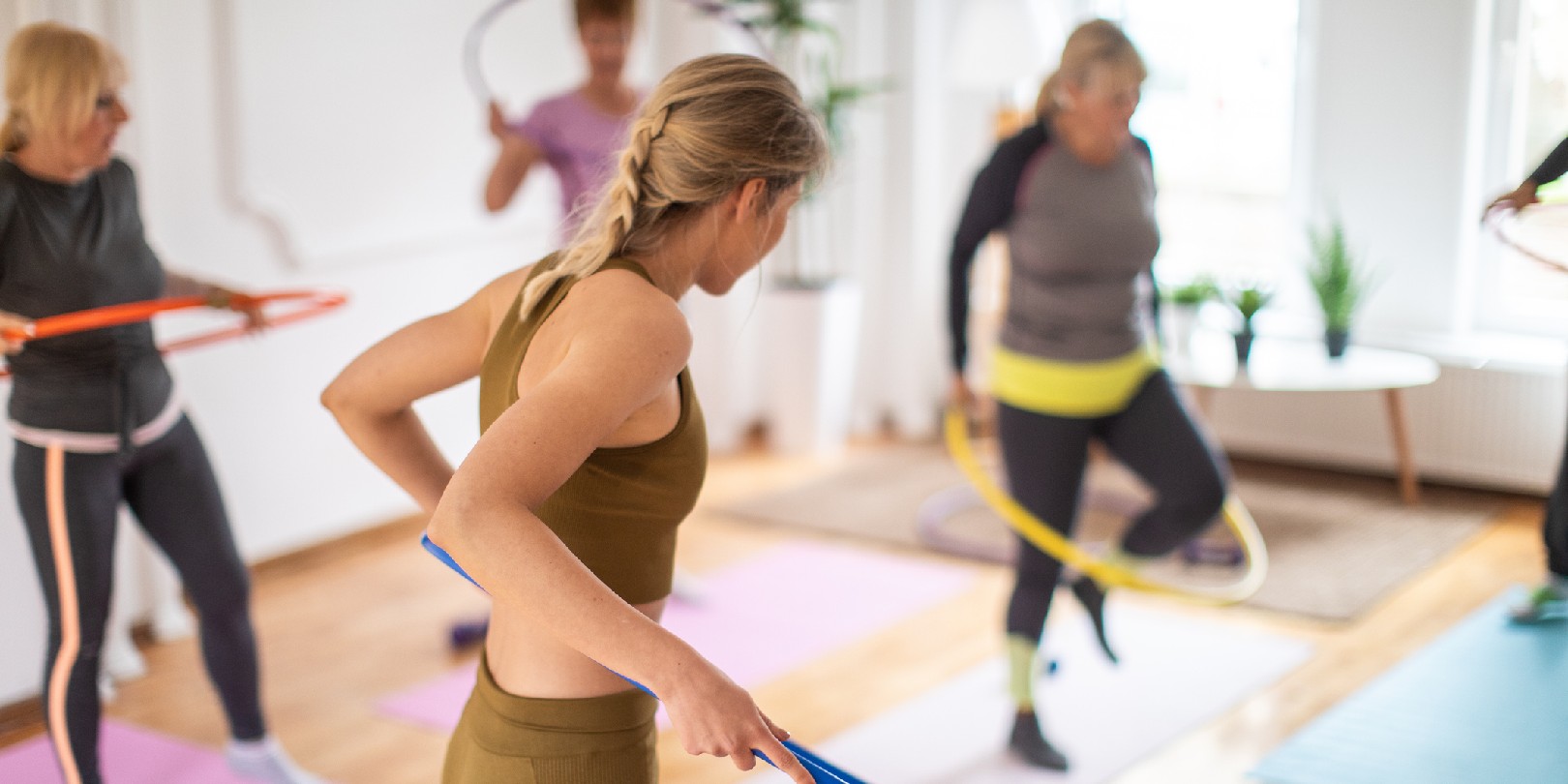 hula-hoop-exercise the-independence Aerobic instructor and senior people practicing with hula hoop during aerobic class