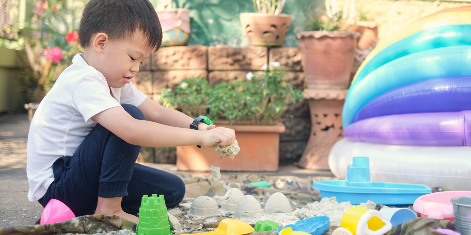 sensory-activities-for-toddlers the-independence Cute Asian 4 - 5 years old toddler boy playing with sand alone at home