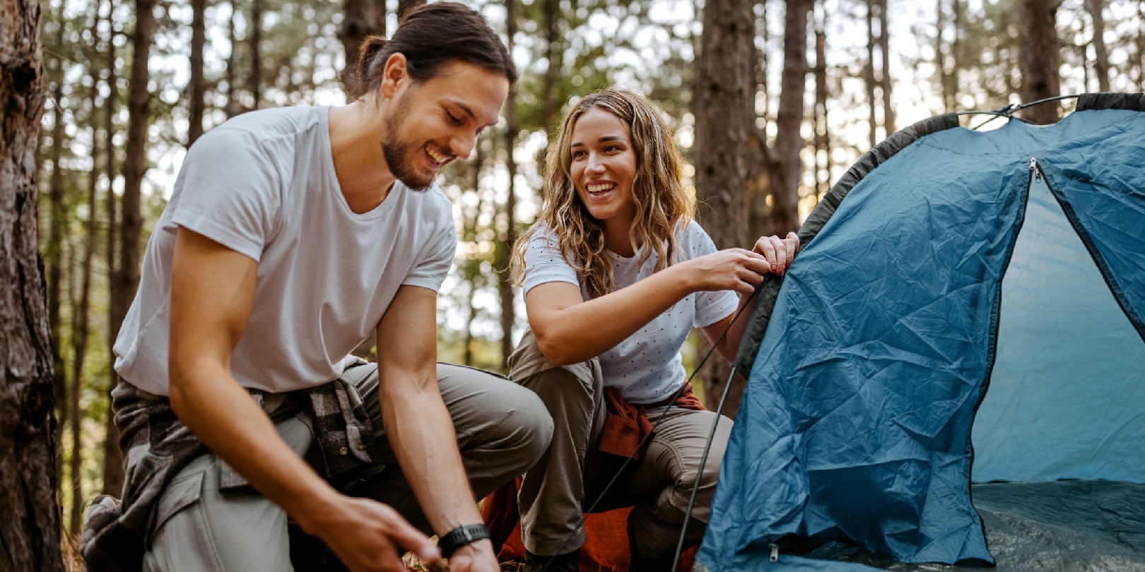 tent-footprint the-independence Beautiful smiling women with handsome boyfriend setting up tent in forest while talking