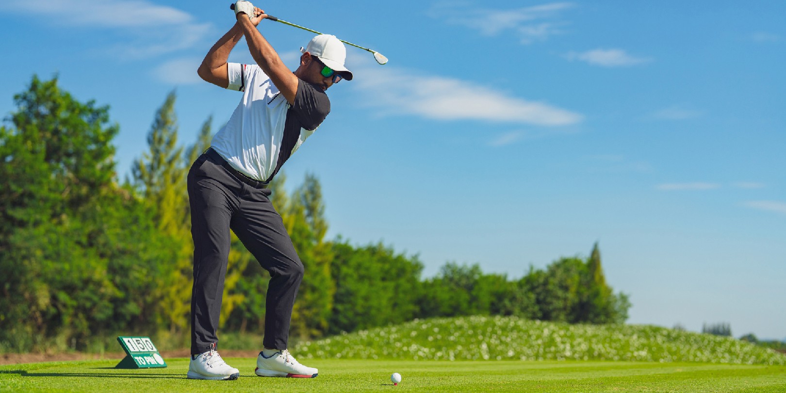 Asian man golfing on the course in summer