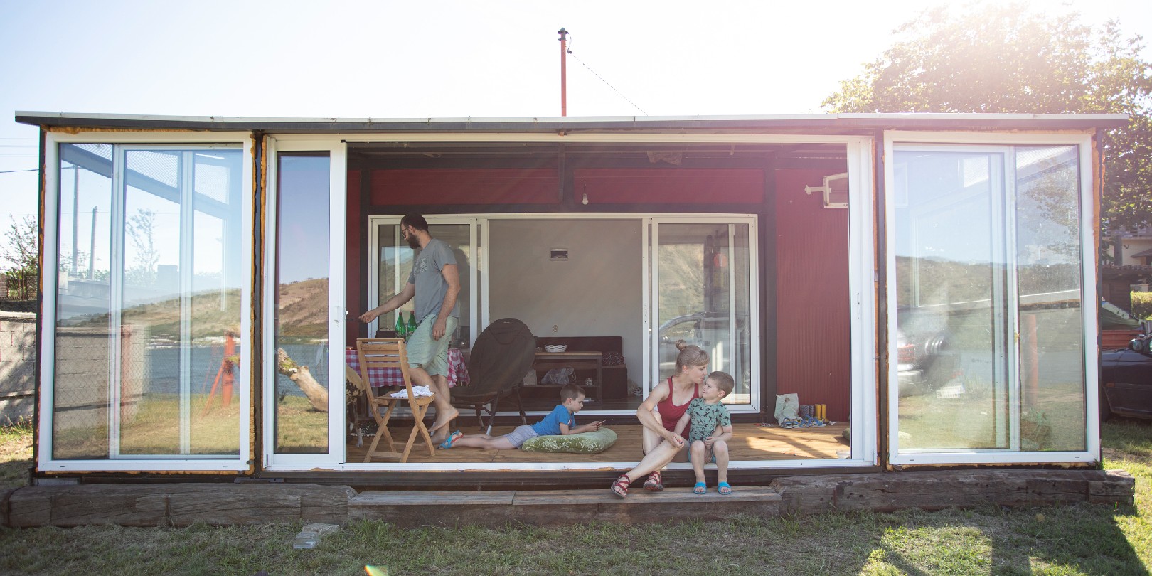 pros-and-cons-of-prefab-homes the-independence Family with two children and a dog enjoying in their container house.