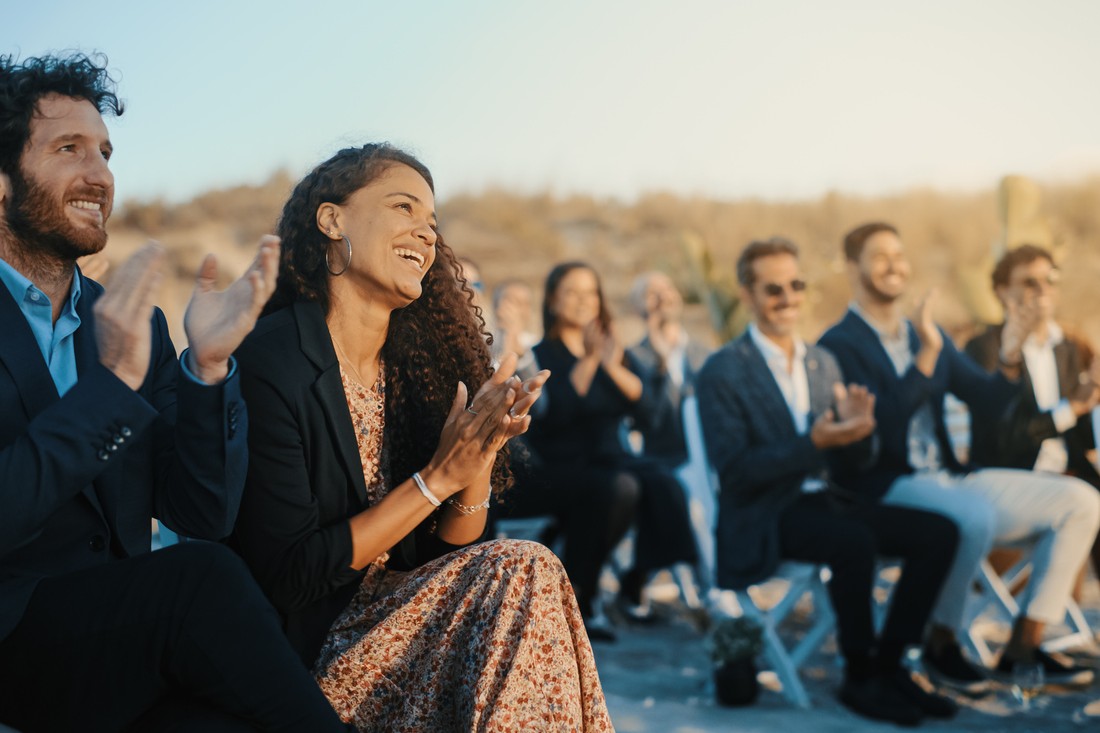 Excited Guests Sitting in an Outdoors Venue and Clapping Hands.